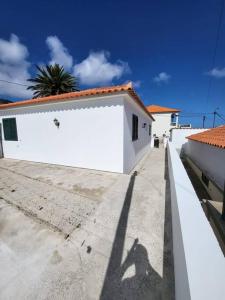 a shadow of a person standing next to a white building at The Believers - Porto Santo in Porto Santo