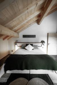 a bedroom with a large bed with a green blanket at La Loge de la Dolarde - Chambre Nord-Est in Prémanon