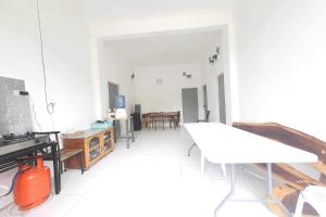 a white living room with a table and chairs at Bohol Transient Lruy near Panglao Beach in Dauis