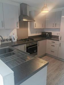 a kitchen with a sink and a stove top oven at Burton House 