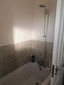 a bathroom with a bath tub with a shower at Burton House 