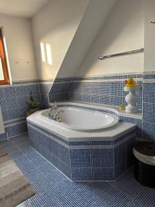 Habitación con baño de azulejos azules con bañera. en Freundliche Wohnung Nähe Weinstraße für 5 Personen, en Wagna