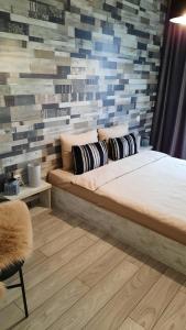 ein Schlafzimmer mit einem großen Bett und einer Ziegelwand in der Unterkunft Grey Residence Apartament in Târgu Mureș