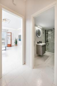 W białej łazience znajduje się umywalka i lustro. w obiekcie Villa Katrin w mieście Kisamos