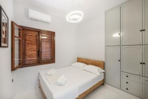 een witte slaapkamer met een bed en een raam bij Villa Katrin in Kissamos