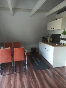 Habitación con cocina, mesa y sillas. en Schöne Ferienwohnung mit Balkon auch für Handwerker und Monteure en Borsfleth