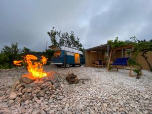 ein Campingplatz mit einem Lagerfeuer im Vordergrund in der Unterkunft Batroun van camping in Batrun