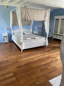 a bedroom with a bed and a wooden floor at La Ptite Normande in Saint-Germain-de-Tournebut