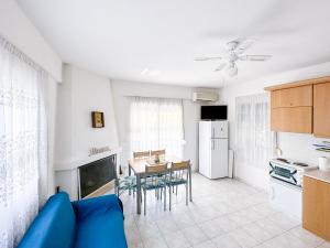a kitchen and living room with a blue couch and a table at myShell House in Polykhrono