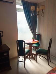 uma mesa e cadeiras num quarto com uma janela em Apartment DREAMS em Sombor