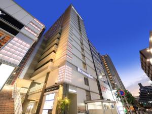 a tall building in the middle of a city at Richmond Hotel Fukuyama Ekimae in Fukuyama