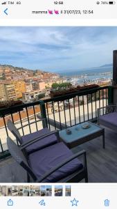 a balcony with chairs and a table and a view of a city at argentario home in Porto Santo Stefano