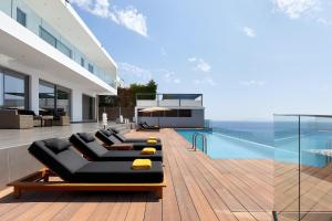 アギア・ペラギアにあるBeachfront Villa in Crete - Epavli Luxury Villaのスイミングプールとブラックカウチ付きの家