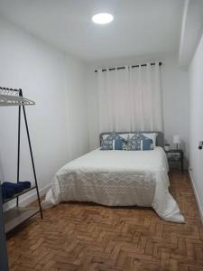 um quarto com uma cama branca e almofadas azuis em Simpático apartamento no centro em Lisboa