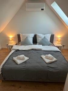 um quarto com uma cama grande com duas toalhas em Ferienwohnung "Kapellmeister" mit Klimaanlage in allen 4 Schlafbereichen, großes Wohnzimmer mit Smart TV und Big Sofa em Magdeburg