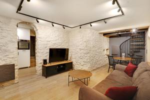 a living room with a couch and a stone wall at Pick A Flat's Apartment in Montmartre - Rue Drevet in Paris