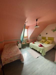 Un dormitorio con dos camas y una mesa y una ventana. en Chambres du Vau-Nogues, en Pleudihen-sur-Rance