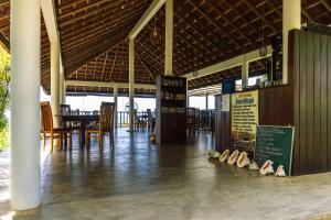 فندق أنانثايا بيتش في تانجالي: صالة طعام فيها طاولات وكراسي وحذاء على الارض