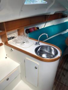 a kitchen with a sink and wine glasses at Jeanneau Sun Way 25 in Hrdoňov