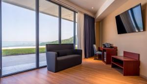 Litz Resort في كفارياتي: غرفة معيشة مع كرسي ومكتب ونافذة