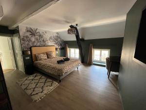 ein Schlafzimmer mit einem Bett und einem Wandgemälde in der Unterkunft Clos Théodore - Appartement climatisé avec sauna, petite terrasse et mezzanine in Givry