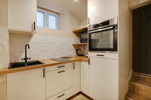 a kitchen with white cabinets and a sink and a microwave at Pick A Flat's Apartment in Montmartre - Rue Drevet in Paris