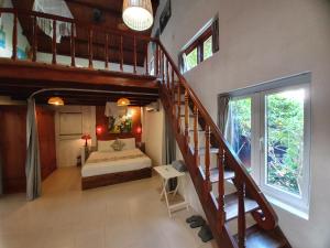 a bedroom with a staircase and a bed in a room at An Bang Hideaway in Hoi An