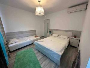 una camera con due letti e un lampadario a braccio di 24 IOR by Green Apartments a Bucarest