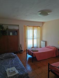 uma sala de estar com duas camas e uma janela em Casa dei Girasoli - Formia centro em Formia