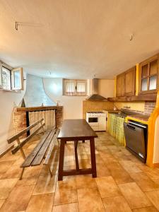eine Küche mit einem Holztisch und einer Bank darin in der Unterkunft Tentadore in La Caletta