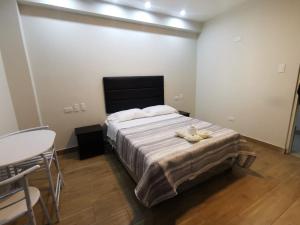 1 dormitorio con 1 cama con mesa y sillas en Hotel Sol de Marcona, en San Juan