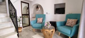 a living room with two blue chairs and a table at Casa en Casco Historico in Córdoba