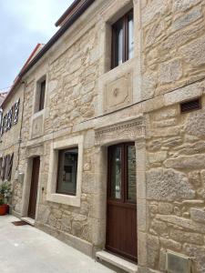 a stone building with a wooden door on it at Villa Mara in Villanueva de Arosa