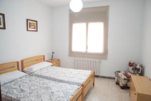 1 dormitorio con 2 camas y 1 silla en Ca l'Armengol Rooms en Balaguer