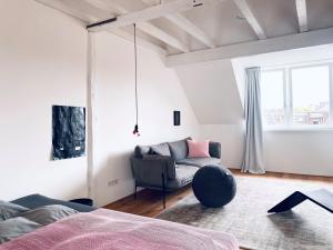 ein Schlafzimmer mit einem Bett, einem Sofa und einem Fenster in der Unterkunft Zehuus mit Domblick und Dachterrasse in Köln