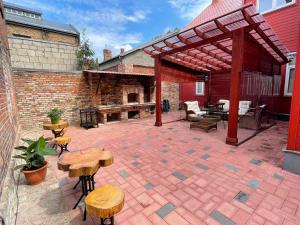 a patio with wooden tables and chairs and a brick building at Karlsons Antique in Liepāja