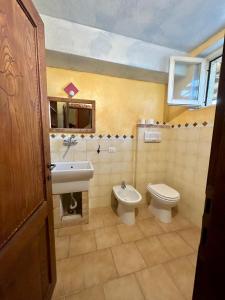ein Bad mit einem WC, einem Bidet und einem Waschbecken in der Unterkunft Tentadore in La Caletta