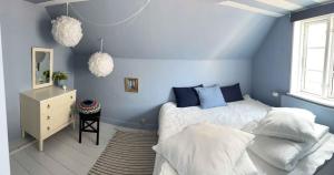 Dormitorio azul con cama y espejo en Tordenskjoldet en Marstal