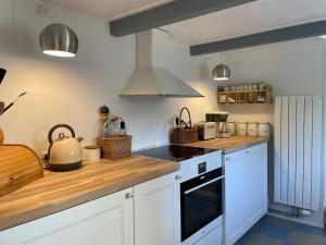 a kitchen with white cabinets and a stove top oven at Tordenskjoldet in Marstal