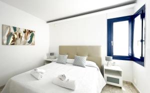 una camera da letto bianca con un letto con due asciugamani sopra di Los Barqueros 24 by Best Holidays Fuerteventura a Corralejo Altre 23 foto