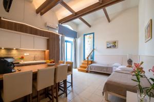 cocina y comedor con mesa y barra en Captain's House Hotel Suites & Apartments, en Panormos Rethymno