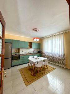 kuchnia z zielonymi szafkami oraz stołem i krzesłami w obiekcie Guest house tirana w Tiranie