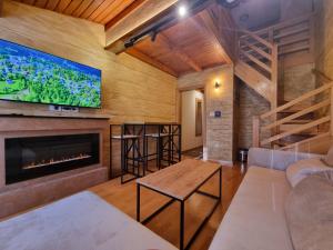 a living room with a fireplace and a flat screen tv at Apartman Lord Aparthotel Vučko in Jahorina
