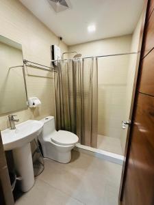 a bathroom with a toilet and a sink and a shower at Jhunbelle in Coron