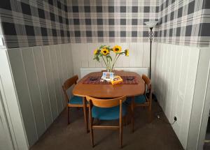 een kleine tafel met een vaas met zonnebloemen erop bij Moulin Cottage in Moulin