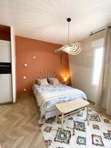 Un dormitorio con una cama y una mesa dentro. en Studio Queen, en Saint-Jean-de-Monts