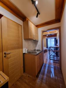 a kitchen with wooden cabinets and a wooden door at Apartman Lord Aparthotel Vučko in Jahorina