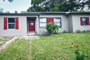 a white house with red shutters and a red door at Spacious Modern 5 Bedrooms JAX in Jacksonville