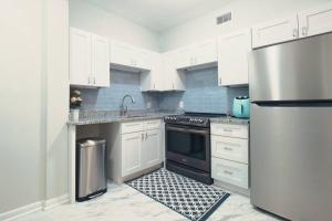 a kitchen with white cabinets and a black refrigerator at Spacious Modern 5 Bedrooms JAX in Jacksonville