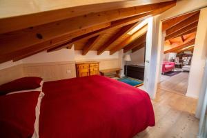 a bedroom with a red bed in a attic at Attico in centro a Folgaria in Folgaria